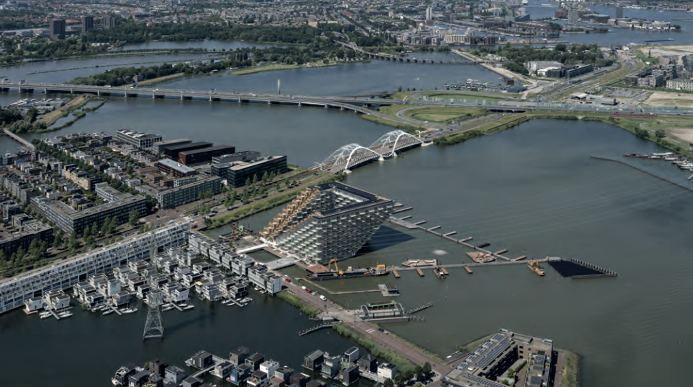 Luftbild eines modernen Hafen- und Wohngebiets mit Brücke und Wasser.